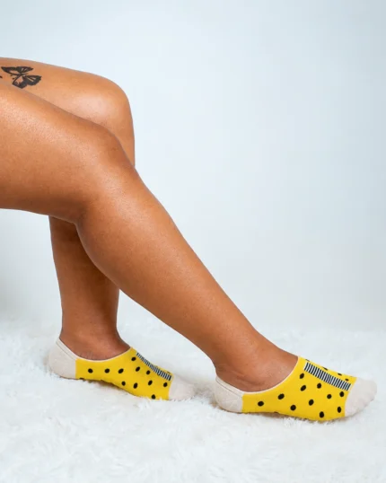 Yellow polka dot boat socks on foot